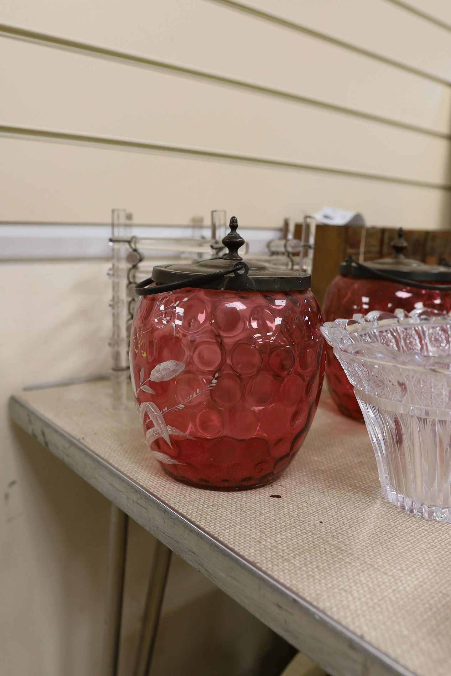 An abstract glass plant pot holder, together with a pair of cranberry glass jars and covers, etc.